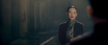Movie still from “The Grandmaster” (2013), directed by Kar-Wai Wong – A woman in a black jacket standing in front of a window; Close Up shot, Over the shoulder angle