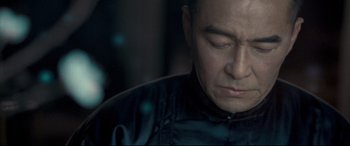 Movie still from “The Grandmaster” (2013), directed by Kar-Wai Wong – A person wearing a black jacket; Close Up shot, Over the shoulder angle