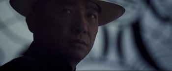 Movie still from “The Grandmaster” (2013), directed by Kar-Wai Wong – A person wearing a hat; Close Up shot, Over the shoulder angle