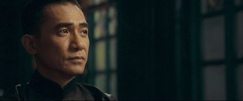 Movie still from “The Grandmaster” (2013), directed by Kar-Wai Wong – A person wearing a suit and tie; Close Up shot, Over the shoulder angle