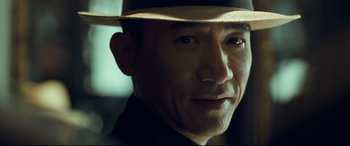 Movie still from “The Grandmaster” (2013), directed by Kar-Wai Wong – A person wearing a hat; Close Up shot, Over the shoulder angle
