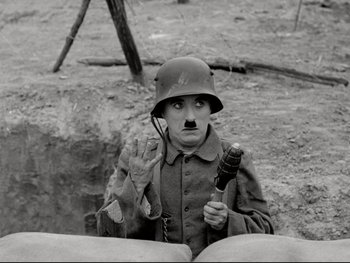 Movie still from “The Great Dictator” (1940), directed by Charles Chaplin – A man in a military uniform holding a microphone; Medium shot, High angle