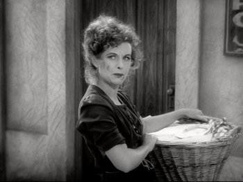 Movie still from “The Great Dictator” (1940), directed by Charles Chaplin – A woman sitting at a table in front of a wicker basket; Medium shot, High angle