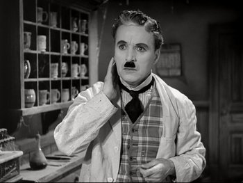Movie still from “The Great Dictator” (1940), directed by Charles Chaplin – A black and white photo of a man with a mustache; Medium shot, Low angle