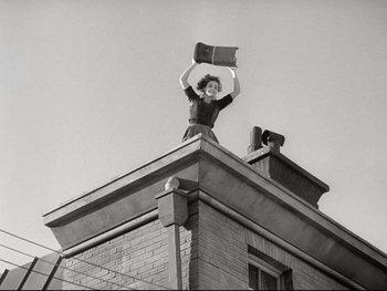 Movie still from “The Great Dictator” (1940), directed by Charles Chaplin – A black and white photo of a woman on top of a building; Wide shot, Low angle
