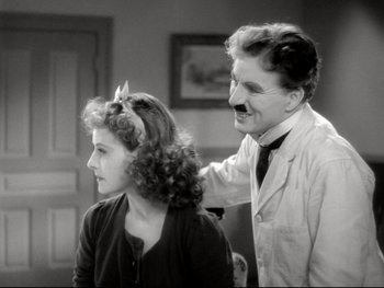 Movie still from “The Great Dictator” (1940), directed by Charles Chaplin – An old photo of a man and a woman; Medium shot, Over the shoulder angle