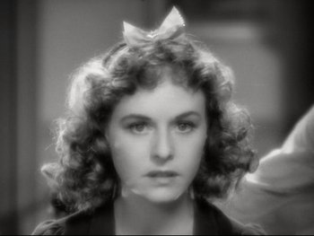 Movie still from “The Great Dictator” (1940), directed by Charles Chaplin – A black and white photo of a woman with curly hair and a bow in her hair; Close Up shot, High angle
