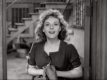 Movie still from “The Great Dictator” (1940), directed by Charles Chaplin – An old photo of a woman smiling for the camera; Medium shot, High angle