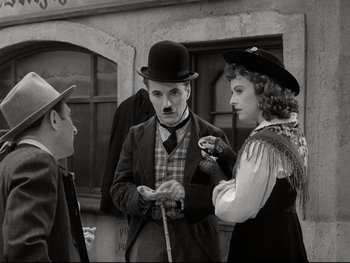 Movie still from “The Great Dictator” (1940), directed by Charles Chaplin – A man and two women standing next to each other; Medium shot, Over the shoulder angle