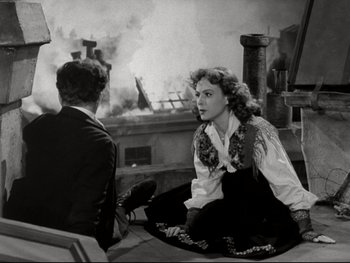 Movie still from “The Great Dictator” (1940), directed by Charles Chaplin – A man and a woman sitting on the ground in front of a fire pit; Medium shot, Overhead angle