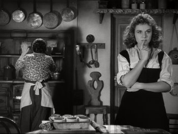 Movie still from “The Great Dictator” (1940), directed by Charles Chaplin – A woman in a kitchen with a bunch of pans on the counter; Medium shot, Over the shoulder angle