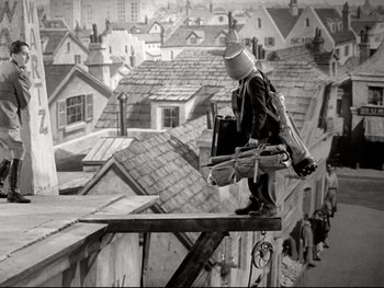 Movie still from “The Great Dictator” (1940), directed by Charles Chaplin – A man standing on the edge of a roof; Wide shot, Low angle