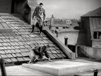 Movie still from “The Great Dictator” (1940), directed by Charles Chaplin – A man standing on top of a roof near another man; Wide shot, High angle