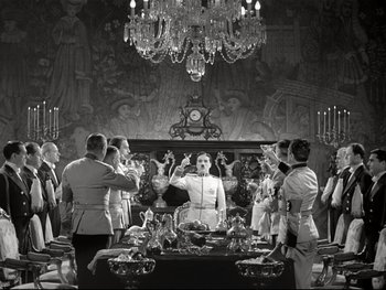 Movie still from “The Great Dictator” (1940), directed by Charles Chaplin – A group of people standing in front of a dining room table; Wide shot, Low angle