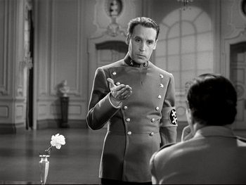 Movie still from “The Great Dictator” (1940), directed by Charles Chaplin – A man in a military uniform talking to a man in a suit; Medium shot, Over the shoulder angle