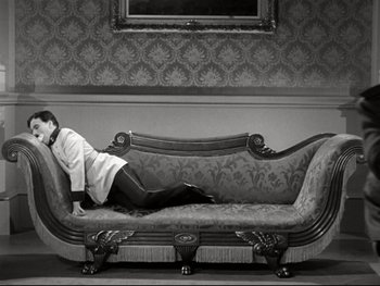 Movie still from “The Great Dictator” (1940), directed by Charles Chaplin – A man laying on a couch in a room; Wide shot, High angle