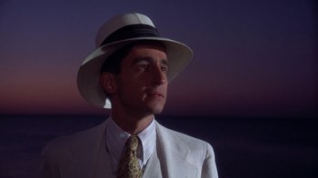 Movie still from “The Great Gatsby” (1974), directed by Jack Clayton – A man wearing a white suit and a white hat; Close Up shot, Low angle