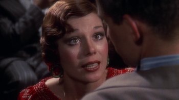Movie still from “The Great Gatsby” (1974), directed by Jack Clayton – An older woman is looking at a younger man; Close Up shot, Over the shoulder angle