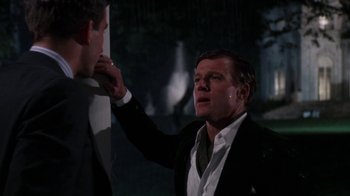 Movie still from “The Great Gatsby” (1974), directed by Jack Clayton – A man in a black suit and a white shirt; Medium shot, Over the shoulder angle