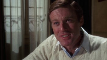 Movie still from “The Great Gatsby” (1974), directed by Jack Clayton – A person wearing a white sweater; Close Up shot, Over the shoulder angle