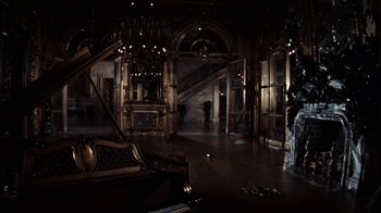 Movie still from “The Great Gatsby” (1974), directed by Jack Clayton – A dark room with a chandelier and a piano; Extreme Wide shot, High angle