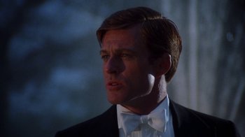 Movie still from “The Great Gatsby” (1974), directed by Jack Clayton – A person wearing a suit and bow tie; Close Up shot, Low angle