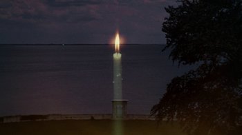 Movie still from “The Great Gatsby” (1974), directed by Jack Clayton – A candle is lit in front of the ocean; Extreme Wide shot, High angle