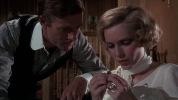 Movie still from “The Great Gatsby” (1974), directed by Jack Clayton – A man and a woman looking at something in a ring; Close Up shot, Over the shoulder angle