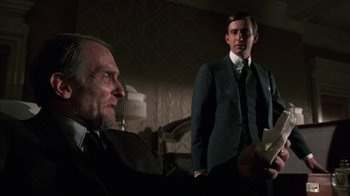 Movie still from “The Great Gatsby” (1974), directed by Jack Clayton – A man in a suit and tie standing next to another man in a suit and tie; Medium shot, Low angle