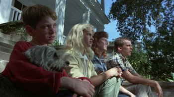 Movie still from “The Great Santini” (1979), directed by Lewis John Carlino – A group of people sitting next to each other on a porch; Medium shot, Low angle