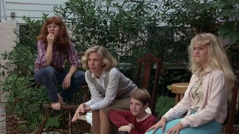 Movie still from “The Great Santini” (1979), directed by Lewis John Carlino – A group of people sitting on chairs in a yard; Medium shot, High angle