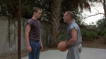 Movie still from “The Great Santini” (1979), directed by Lewis John Carlino – Two men standing next to each other holding a basketball; Medium shot, Low angle