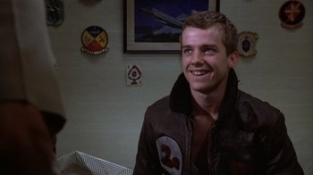 Movie still from “The Great Santini” (1979), directed by Lewis John Carlino – A man in a jacket smiles for the camera; Close Up shot, Over the shoulder angle
