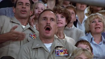 Movie still from “The Great Santini” (1979), directed by Lewis John Carlino – A group of men and women watching a performance; Close Up shot, Low angle