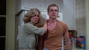 Movie still from “The Great Santini” (1979), directed by Lewis John Carlino – A woman and a young man are standing in a kitchen; Medium shot, Low angle
