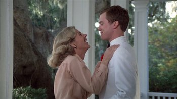 Movie still from “The Great Santini” (1979), directed by Lewis John Carlino – A man and a woman are laughing together outside; Medium shot, Low angle