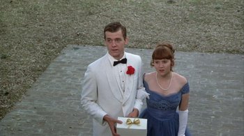 Movie still from “The Great Santini” (1979), directed by Lewis John Carlino – A man and a woman holding a gift box; Medium shot, High angle
