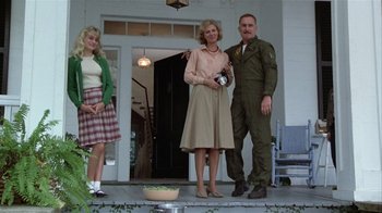 Movie still from “The Great Santini” (1979), directed by Lewis John Carlino – A man and two women standing on a porch; Wide shot, Low angle