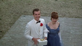 Movie still from “The Great Santini” (1979), directed by Lewis John Carlino – A man and a woman holding a gift box; Medium shot, Overhead angle