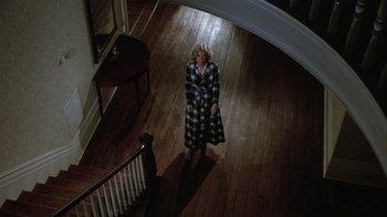 Movie still from “The Great Santini” (1979), directed by Lewis John Carlino – A woman standing in the middle of a wooden floor; Wide shot, Overhead angle