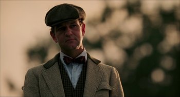 Movie still from “The Greatest Game Ever Played” (2005), directed by Bill Paxton – A man wearing a bow tie and a hat; Close Up shot, Low angle