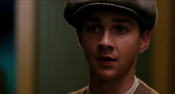 Movie still from “The Greatest Game Ever Played” (2005), directed by Bill Paxton – A young man wearing a hat and looking at the camera; Close Up shot, High angle