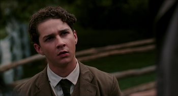 Movie still from “The Greatest Game Ever Played” (2005), directed by Bill Paxton – A man in a suit and tie looking at the camera; Close Up shot, Low angle