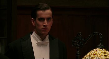 Movie still from “The Greatest Game Ever Played” (2005), directed by Bill Paxton – A man in a tuxedo standing in front of a cross; Close Up shot, Low angle