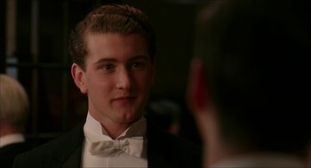 Movie still from “The Greatest Game Ever Played” (2005), directed by Bill Paxton – A man in a tuxedo looking at another man in a suit; Close Up shot, Over the shoulder angle