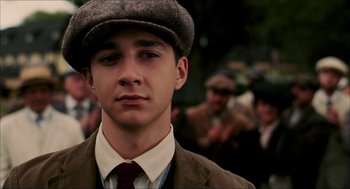 Movie still from “The Greatest Game Ever Played” (2005), directed by Bill Paxton – A young man wearing a suit and a hat; Close Up shot, Low angle