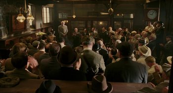 Movie still from “The Greatest Game Ever Played” (2005), directed by Bill Paxton – A group of people sitting in front of a crowd; Wide shot, High angle