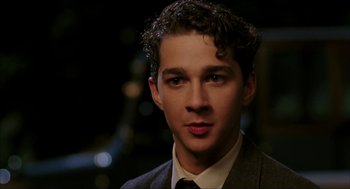 Movie still from “The Greatest Game Ever Played” (2005), directed by Bill Paxton – A man in a suit and tie looking at the camera; Close Up shot, High angle