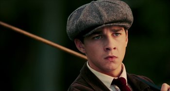 Movie still from “The Greatest Game Ever Played” (2005), directed by Bill Paxton – A young man wearing a hat and a tie; Close Up shot, Low angle