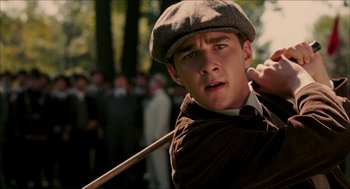 Movie still from “The Greatest Game Ever Played” (2005), directed by Bill Paxton – A man holding a wooden stick in his hand; Close Up shot, Low angle